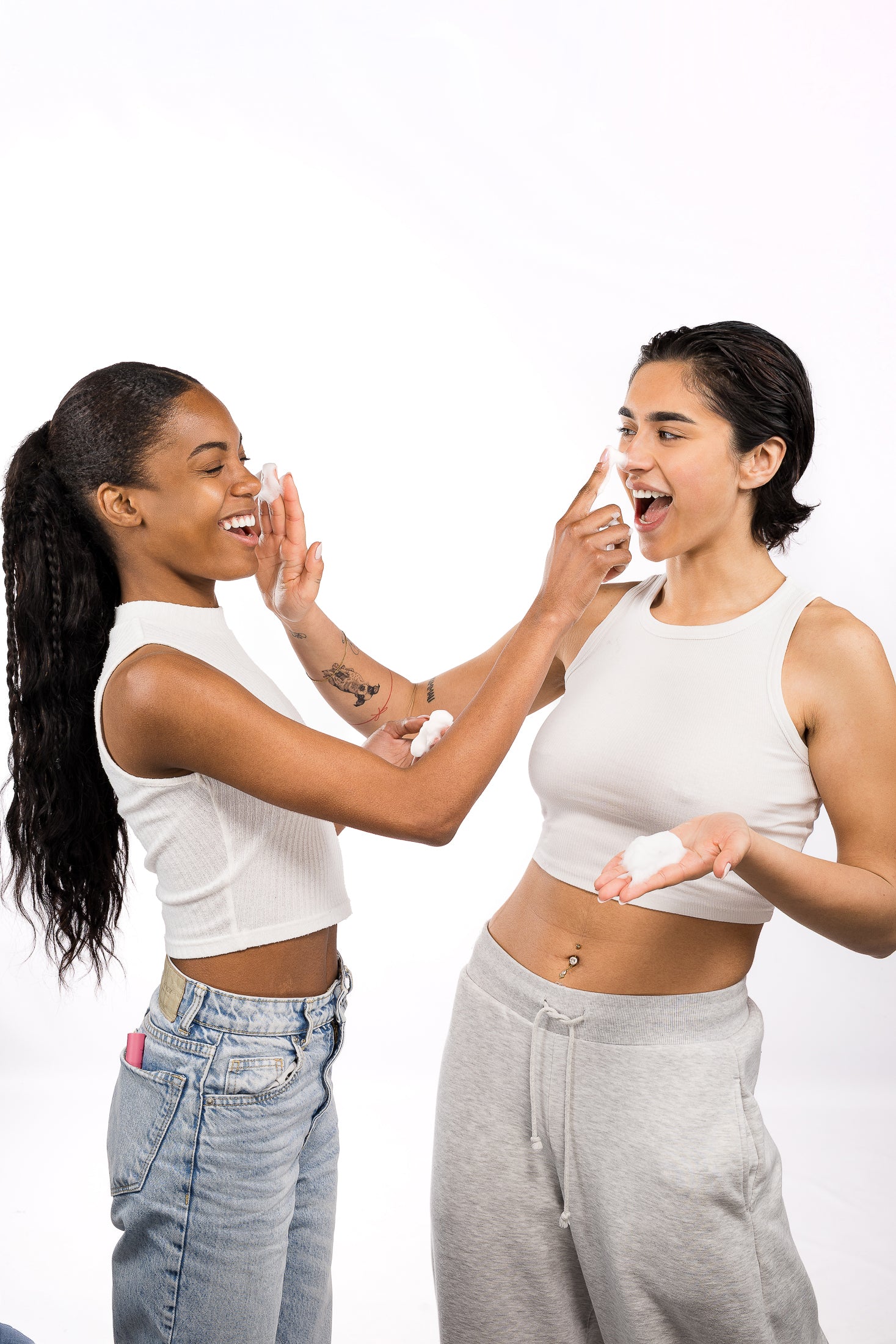 Due amiche applicano prodotti skincare sul viso