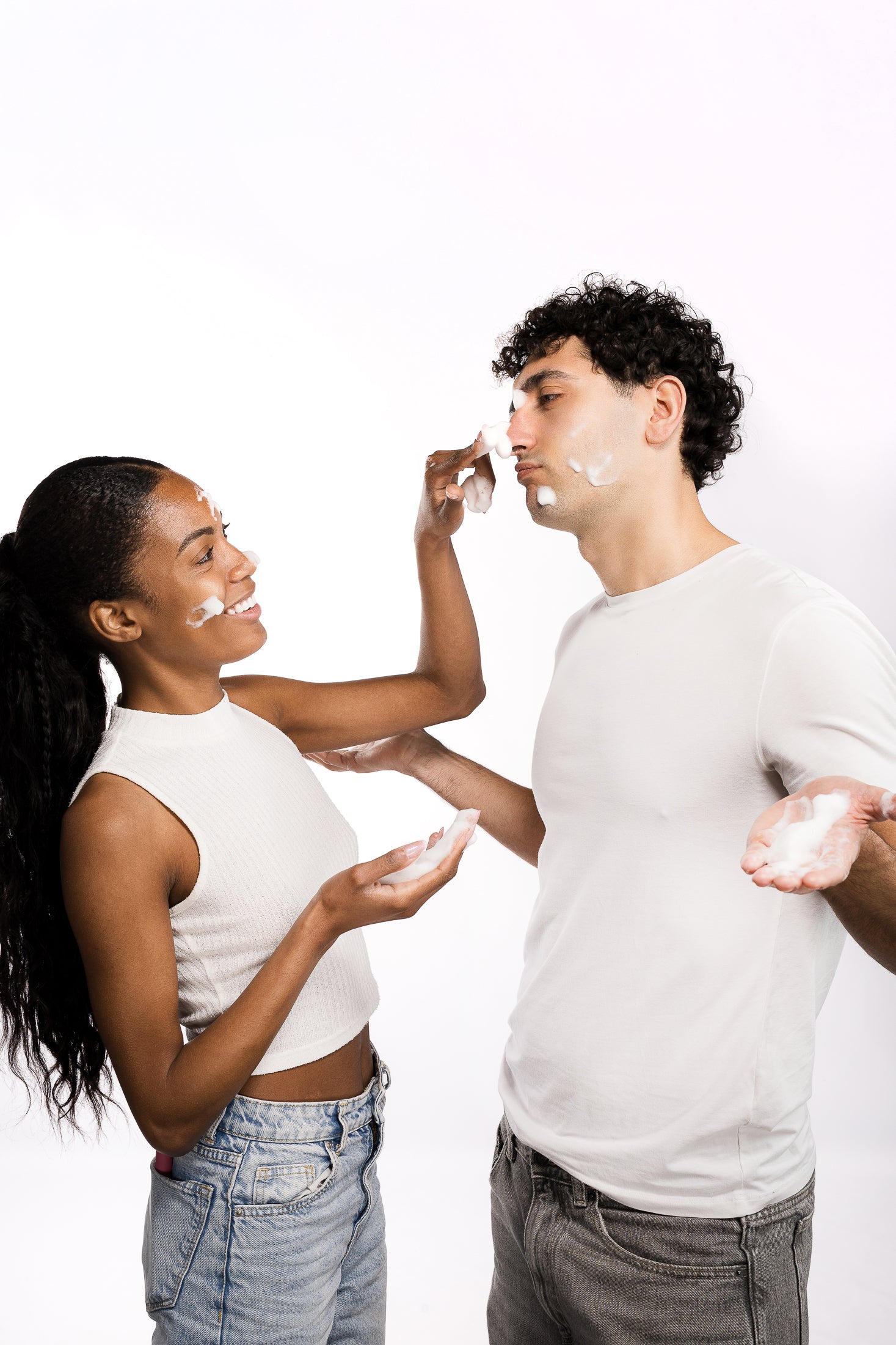 Coppia condivide un momento di skincare applicando una crema viso