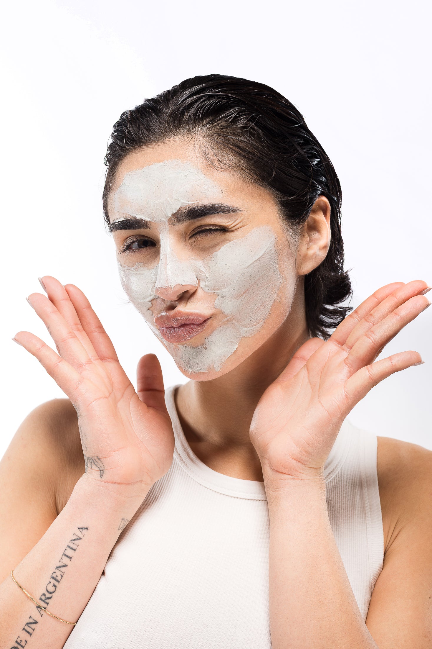 Mia Zottoli con maschera viso durante la skincare routine, mani sollevate in posa giocosa