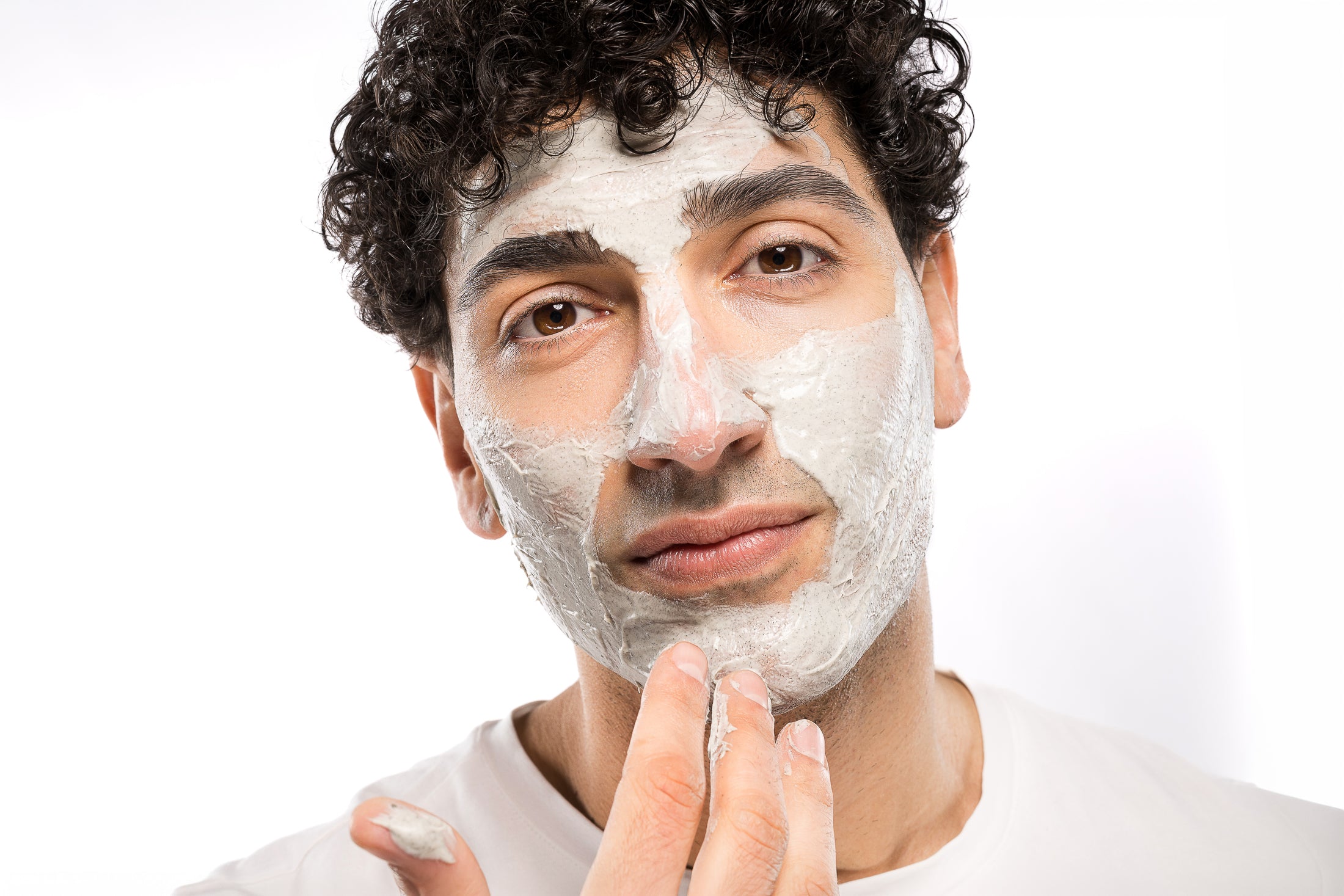 Uomo con maschera viso durante la sua routine di skincare