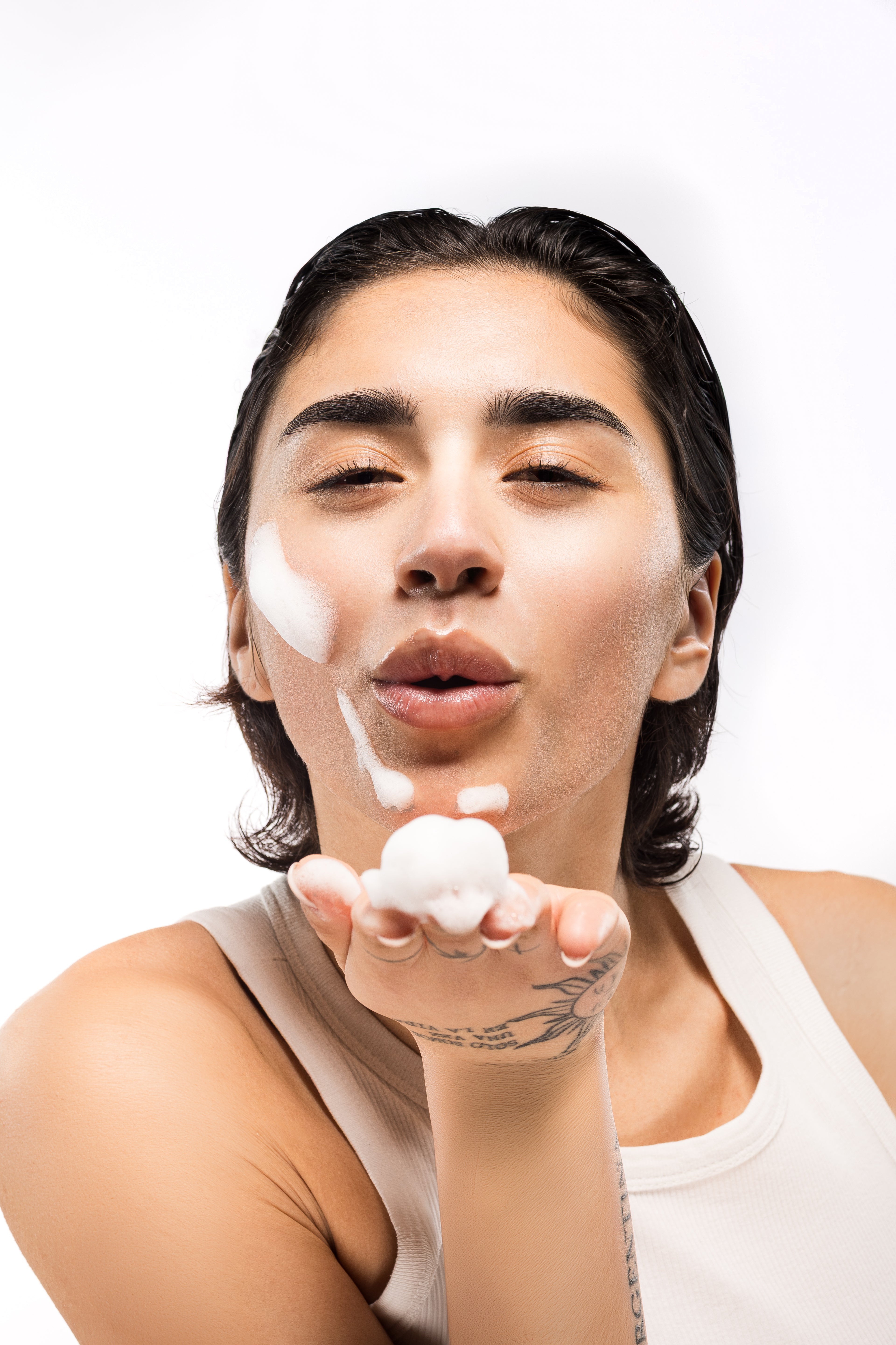 Mia Zottoli soffia una noce di crema skincare dal palmo della mano