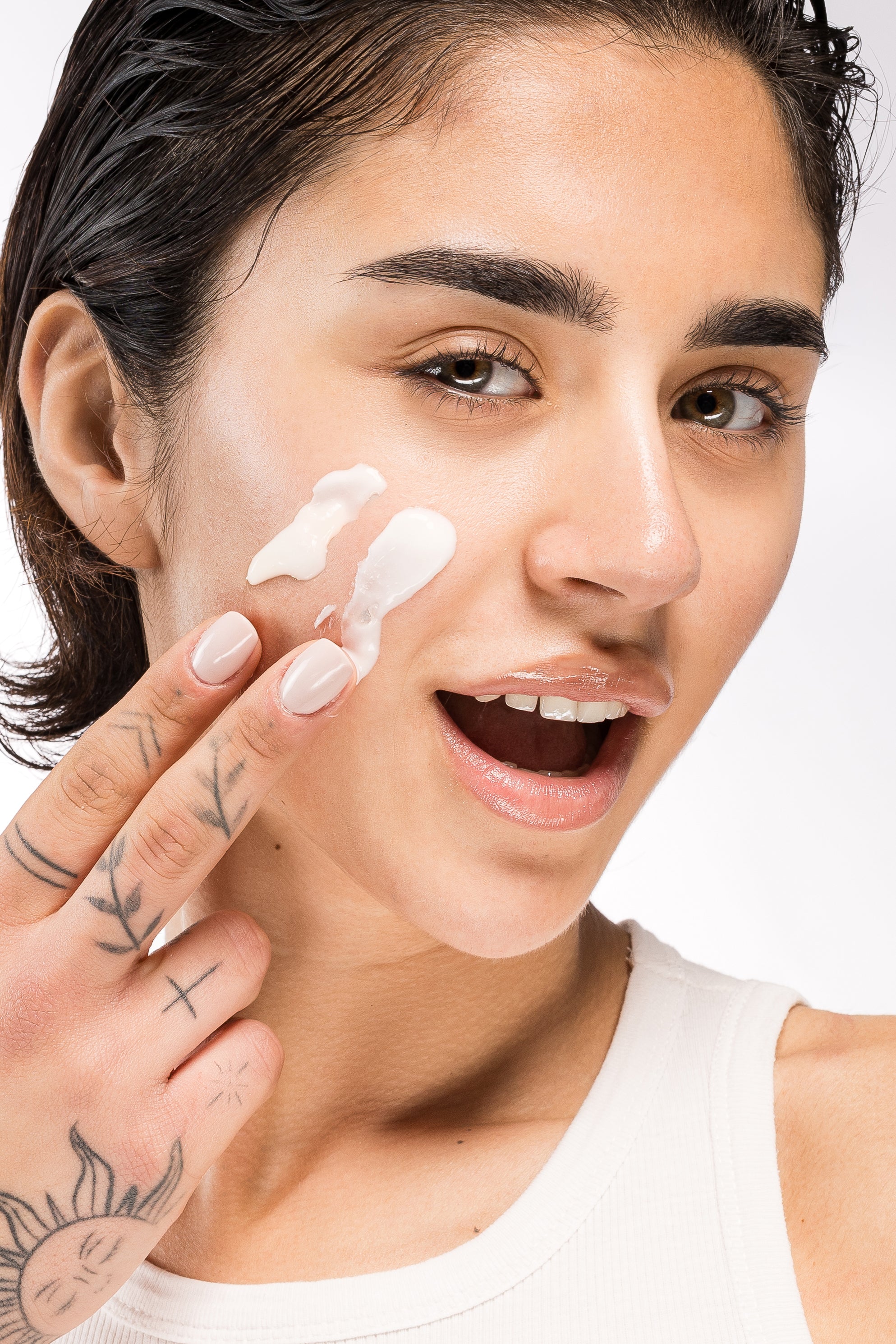 Mia Zottoli applica una crema viso sulla guancia durante la skincare routine